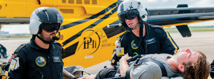 Paramedics in front of a yellow Air Med helicopter