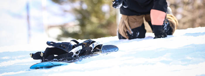 Snow sports safety scenario with snowboarder separated from board on snowy mountain slope