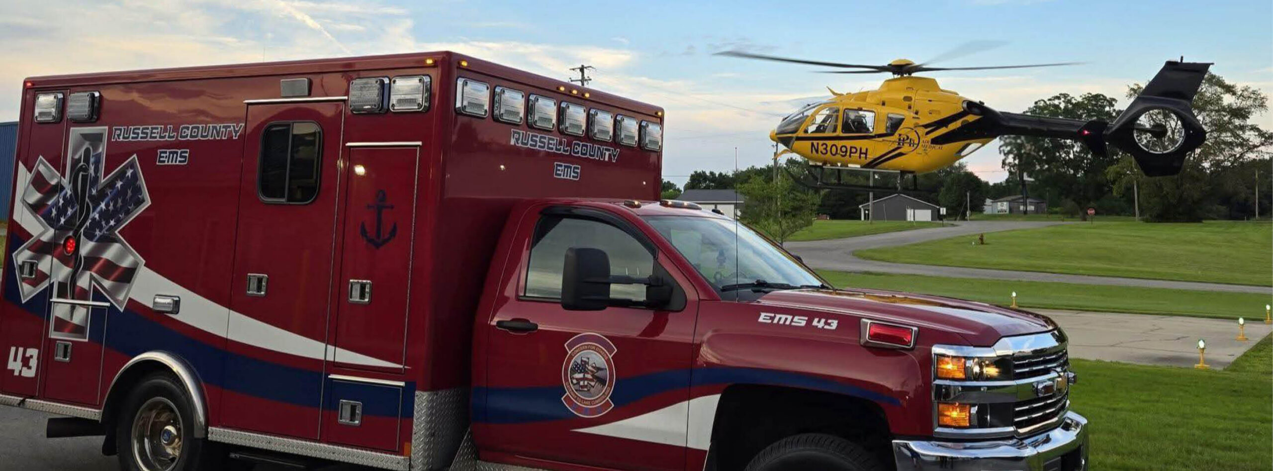 PHI Air Medical helicopter landing near EMS ambulance at roadside landing zone