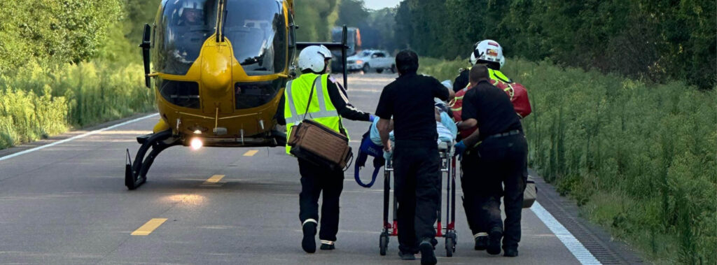 PHI Air Medical patient transfer at highway helicopter landing zone with EMS crews