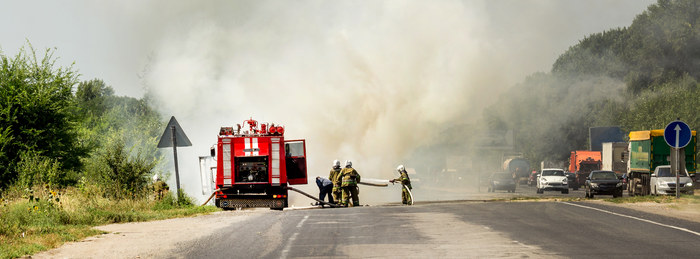 Fire crew working a roadside incident on a rural two-lane highway.
