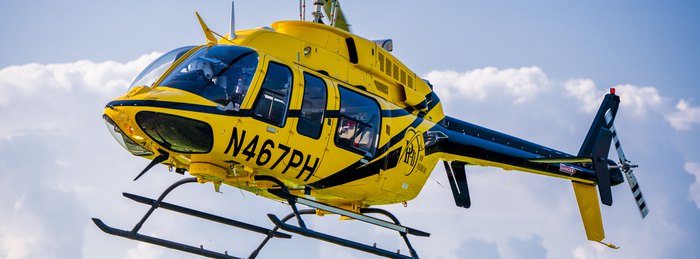 PHI Air Medical helicopter in flight for an interfacility critical care transport.