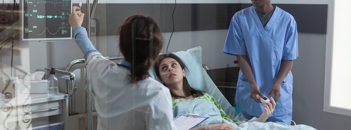 Emergency department clinicians assessing a patient for sepsis warning signs.