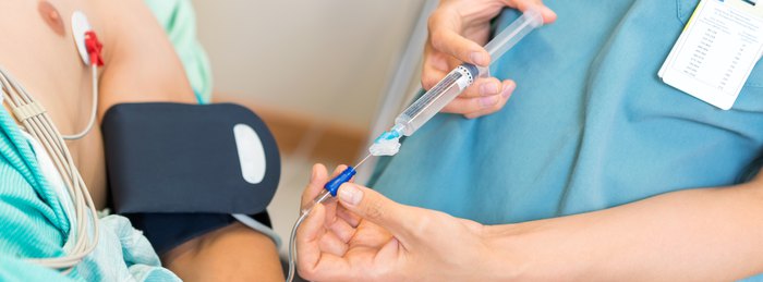 Clinician starting an intravenous line to treat sepsis with antibiotics and fluids.