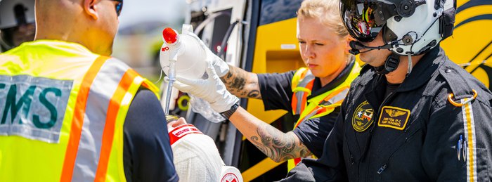 PHI Air Medical flight crew managing intravenous fluids during a patient transport.