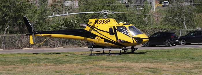 PHI Air Medical helicopter landed in a field beside a residential road.
