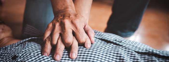 Bystander performing hands-only CPR chest compressions on an adult.