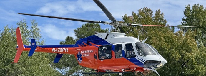 Enterprise Rescue branded helicopter lifting off, a cooperative air medical program aircraft flown by PHI Air Medical crews.
